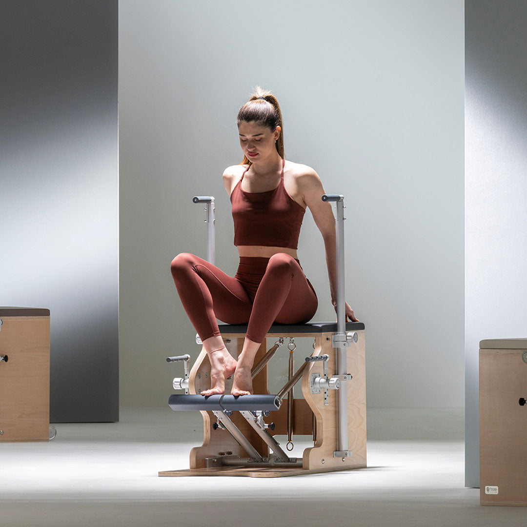 A woman practicing Pilates on a BASI Wunda Chair